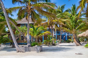 Een privéstrand, wit zand, ligstoelen aan het strand, parasols