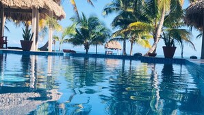 Una piscina al aire libre, sillones reclinables de piscina