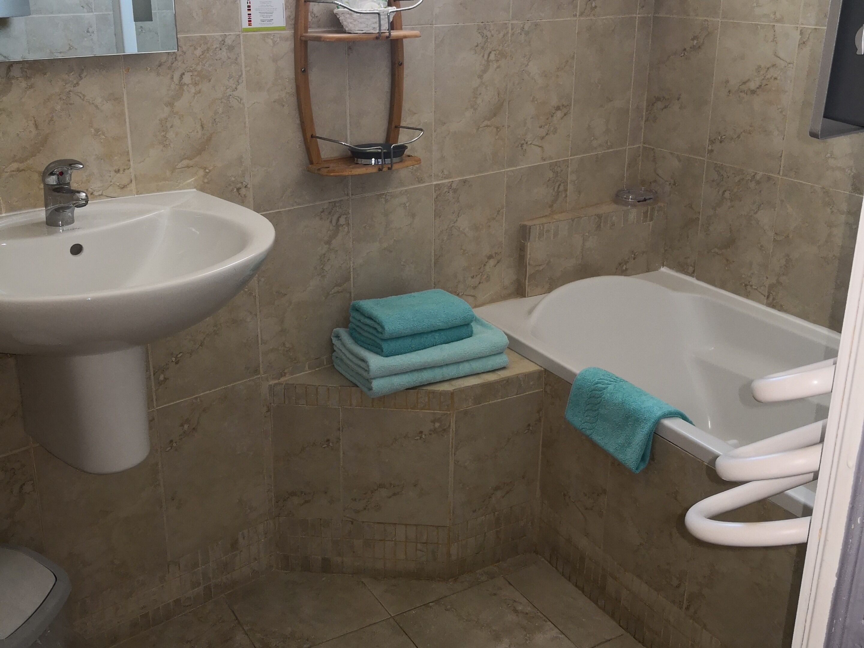 A bathroom with a sink, a bathtub, and a towel rack.