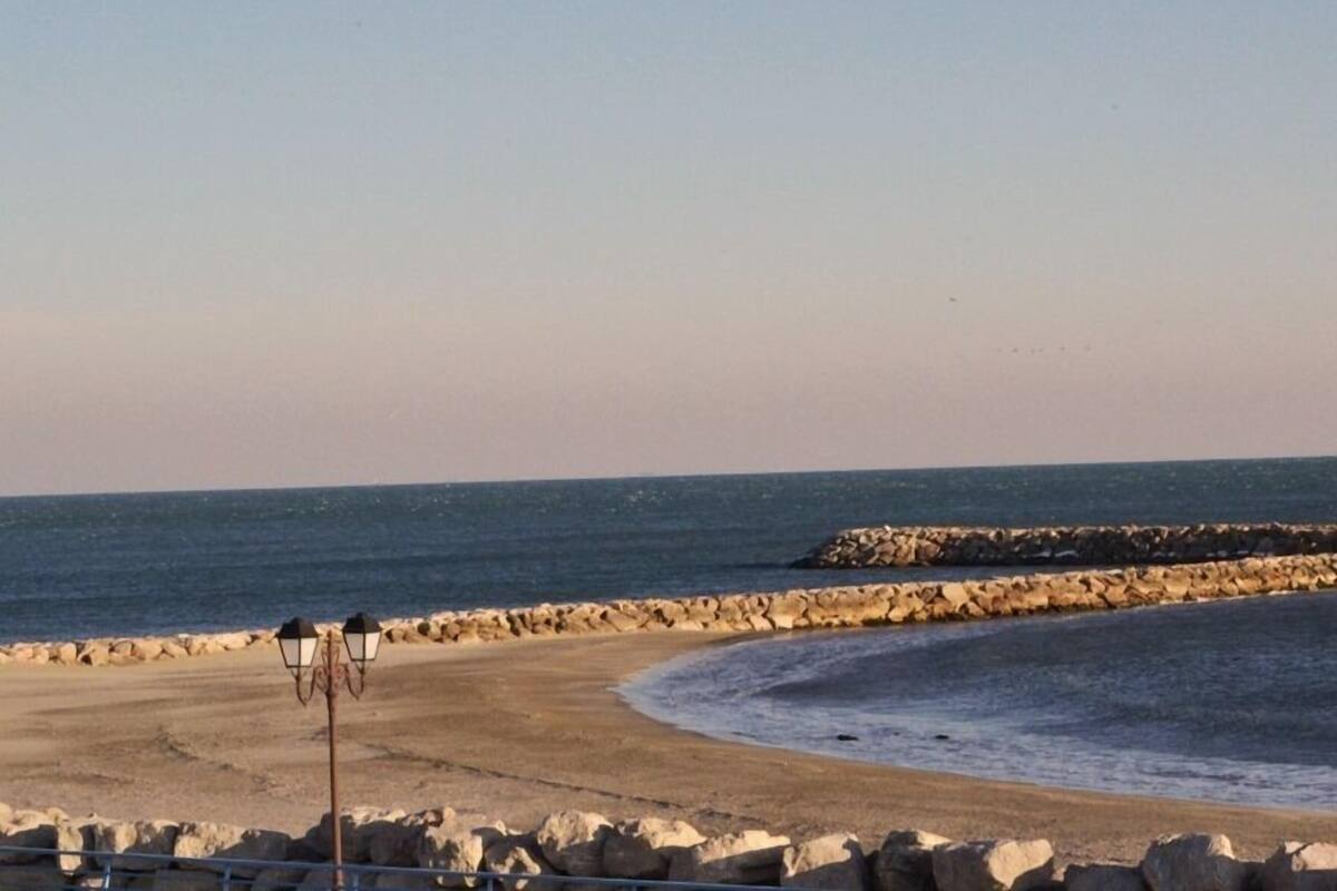 A beach with a stone wall and a lamp post.