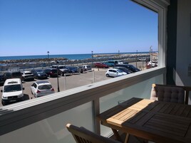 Un balcón con vista a un estacionamiento y la playa.