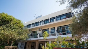 A multi-story building with balconies, outdoor seating, and potted plants. - Flora Maria Hotel (Ayia Napa)
