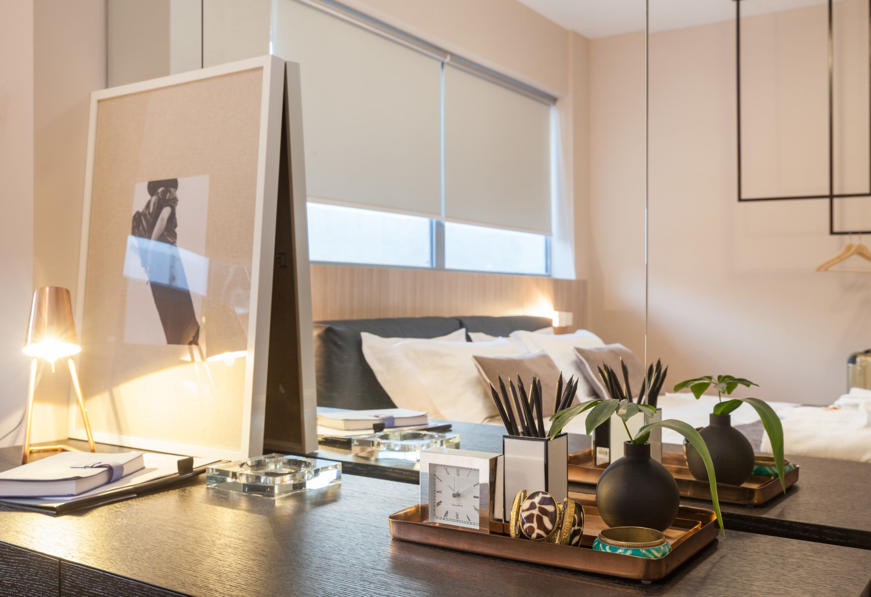 A neatly arranged hotel room with a bed, bedside table, and a large window.