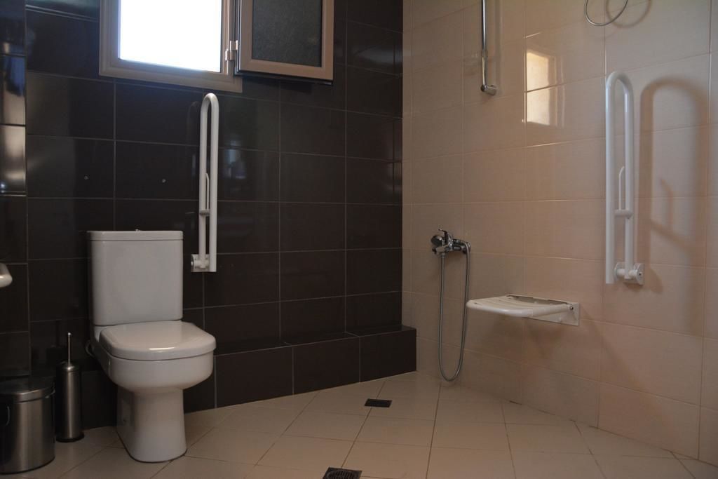 A modern bathroom with a toilet, a shower, and a sink.