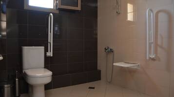A modern bathroom with a toilet, a shower, and a sink.