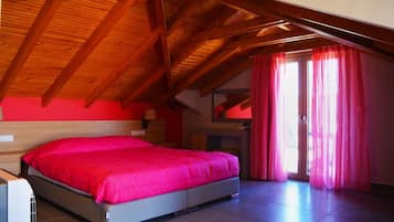 A bedroom with a wooden ceiling, a bed with a pink bedspread, and a sliding glass door with pink curtains.