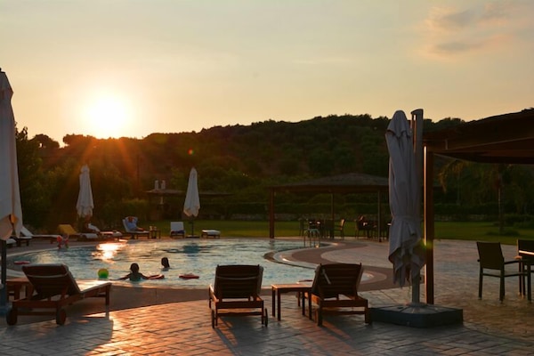 Una piscina al aire libre, sillones reclinables de piscina