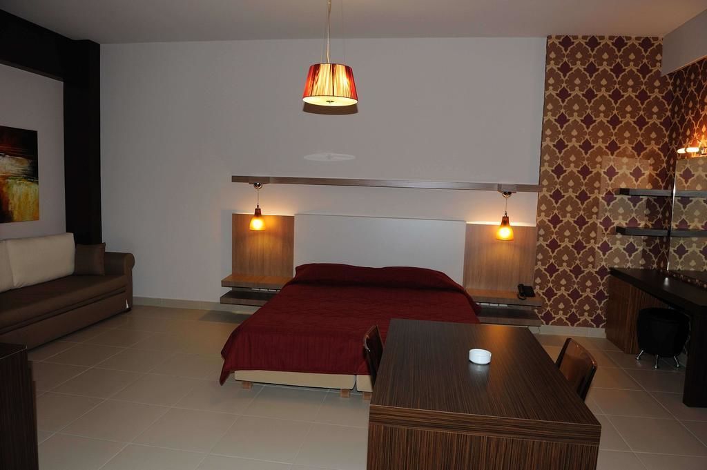 Ein modernes Schlafzimmer mit Bett, Nachttischen, einem Schreibtisch und einem Sessel.