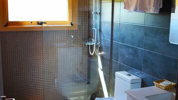 Un baño moderno con ducha, inodoro y lavamanos.
