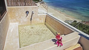 A large bathtub with a view of a beach and ocean. - Maria Del Mar Tulum (Tulum)