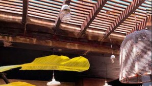 An outdoor kitchen with a stone countertop, hanging yellow leaf decorations, and wooden stools. - Maria Del Mar Tulum (Tulum)