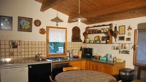 Una cocina con armarios de madera, estufa, lavaplatos y ventana.