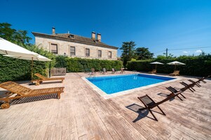 Una piscina al aire libre, tumbonas