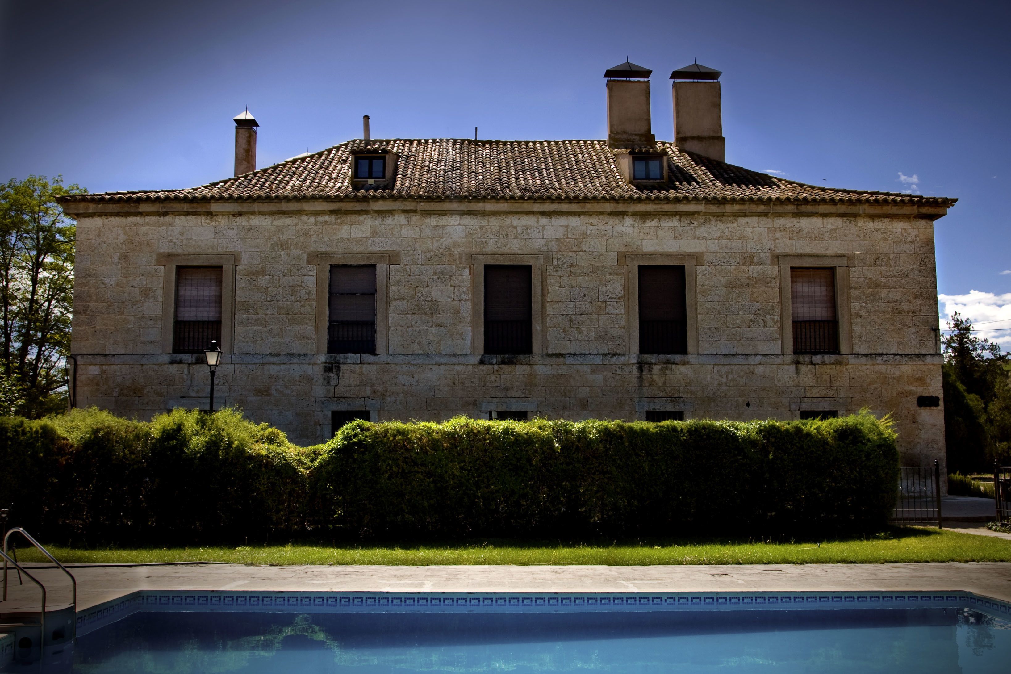 Een buitenzwembad en ligstoelen