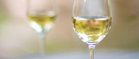 Two wine glasses on a wooden surface with a blurred natural background.