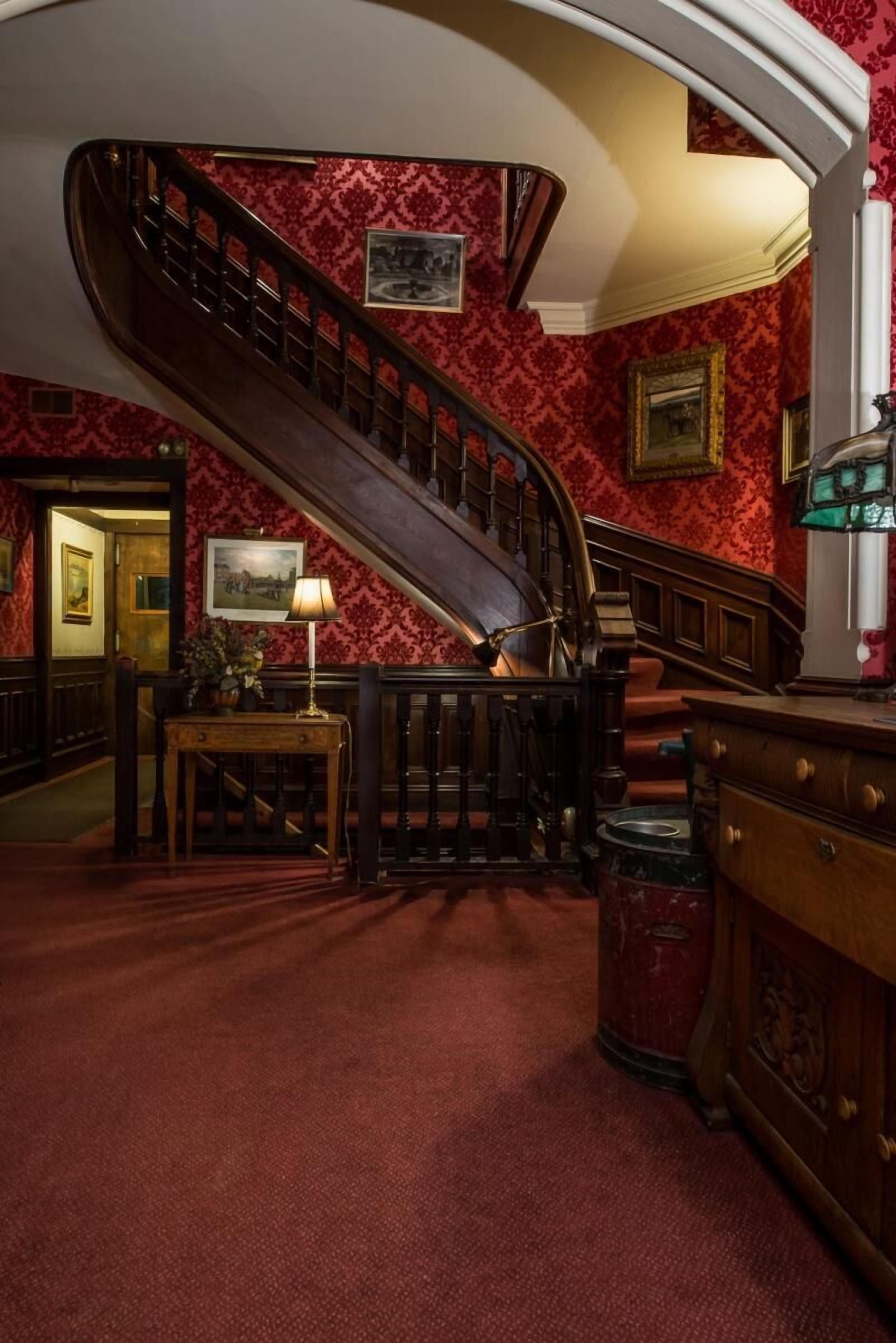 Eine prächtige Treppe mit aufwendiger Balustrade, die zu einer oberen Etage führt.