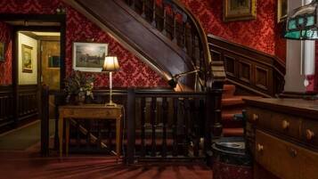 Eine prächtige Treppe mit aufwendiger Balustrade, die zu einer oberen Etage führt.