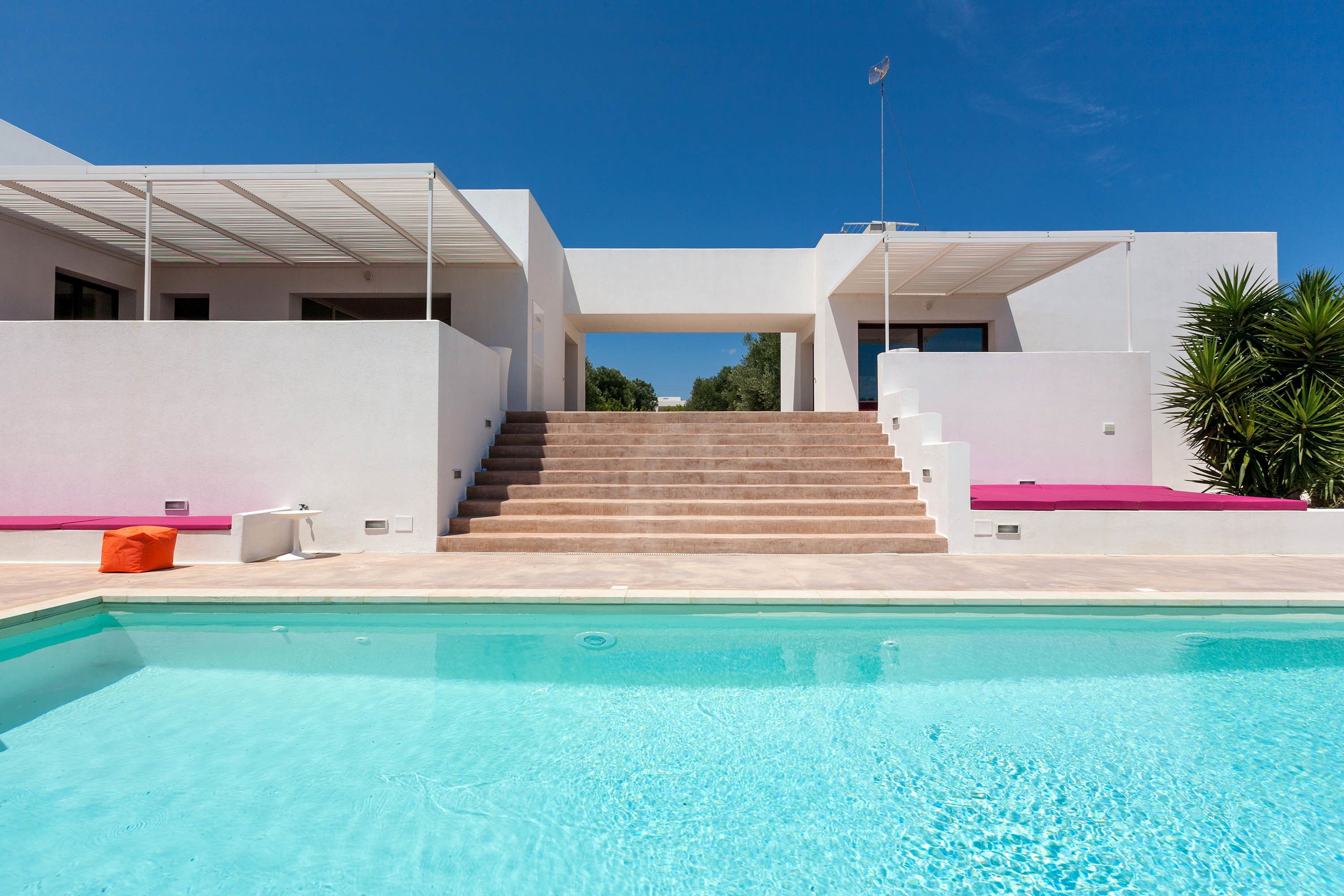 En säsongsöppen utomhuspool, parasoller och solstolar