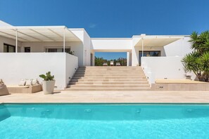A modern house with a swimming pool, a staircase leading to the entrance, and a covered outdoor seating area. - Villa Karma (Carovigno)