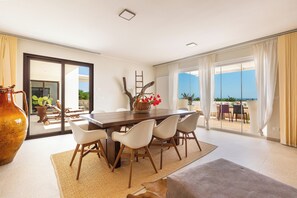 A dining area with a large table, chairs, and a view of the sea through large windows. - Villa Karma (Carovigno)