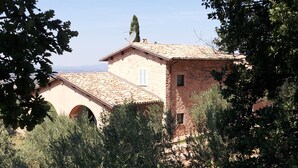A stone building with a tiled roof, arched windows, and a satellite dish. - La Quercetta (Foligno)