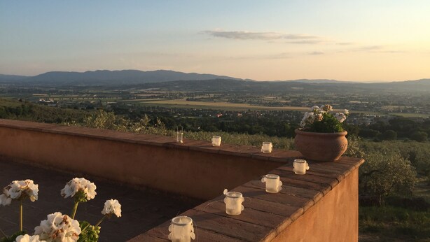 A terrace with a view of distant hills and a town. There are potted plants and candles on the ledge. - La Quercetta (Foligno)