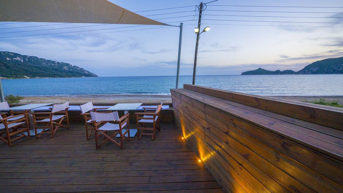 Une terrasse en bois avec des sièges extérieurs et une vue sur la mer.