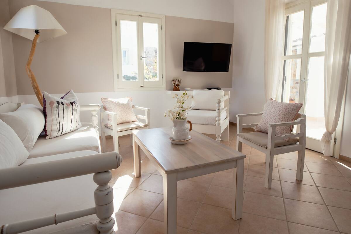 Ein modernes Wohnzimmer mit einer Couch, einem Sessel und einem Couchtisch.
