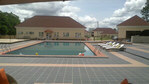 An outdoor swimming pool with lounge chairs and a tiled deck. - Jorany Hotel Resort Ikom (Ikom)