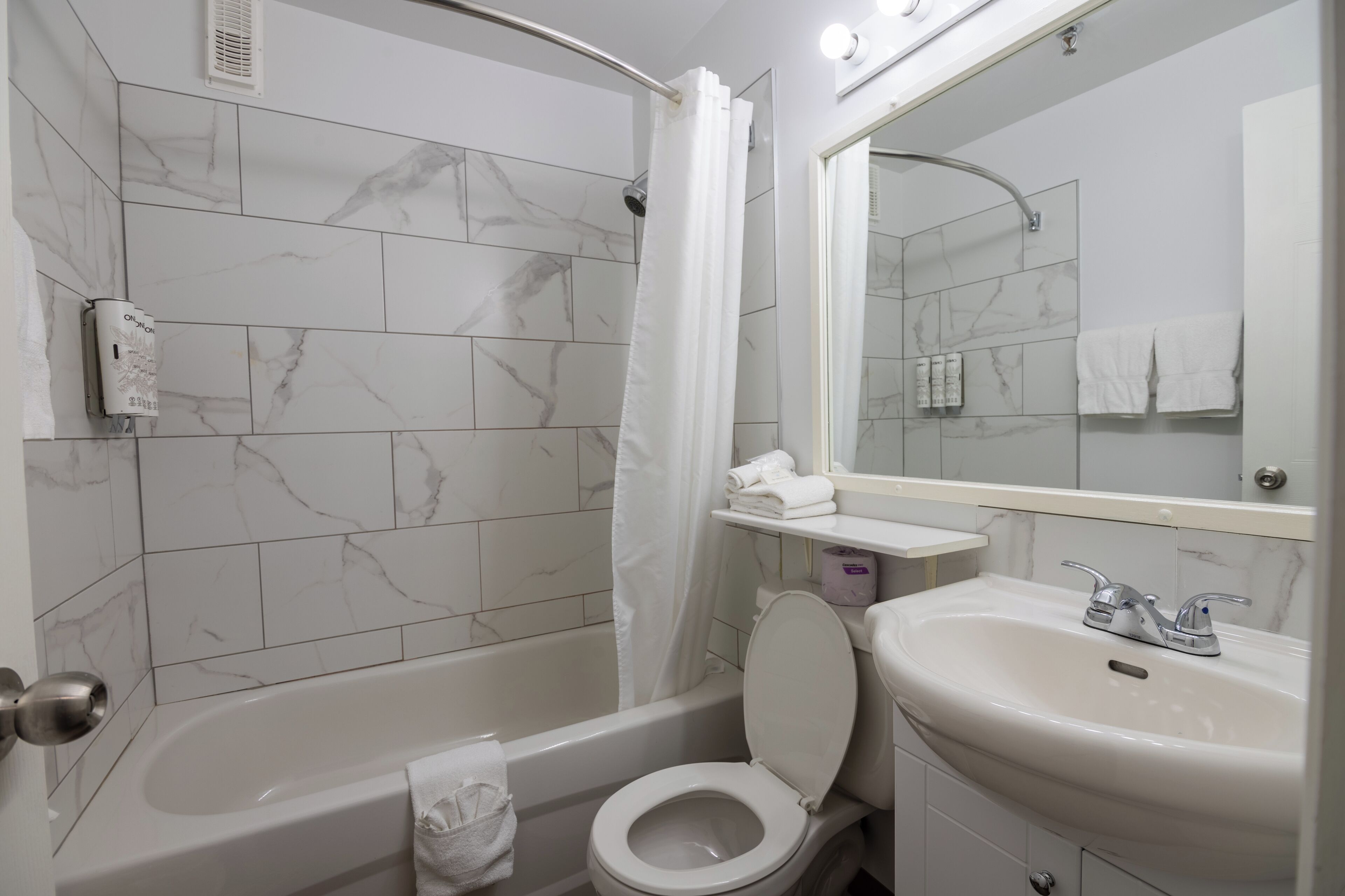 A bathroom with a bathtub, toilet, and sink.