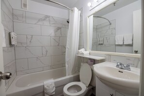 A bathroom with a bathtub, toilet, and sink. - Hotel Les Mouettes (Sept-Iles)