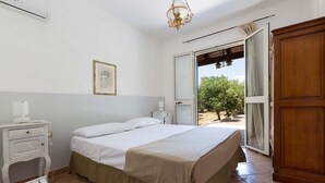 Une chambre à coucher avec un lit, une table de chevet et une armoire.