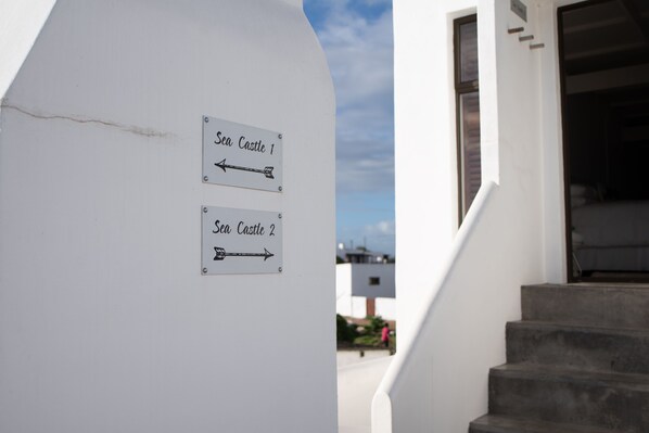 A wall with two directional signs for 'Sea Castle 1' and 'Sea Castle 2'. - SaWestCoast & Beyond (Paternoster)
