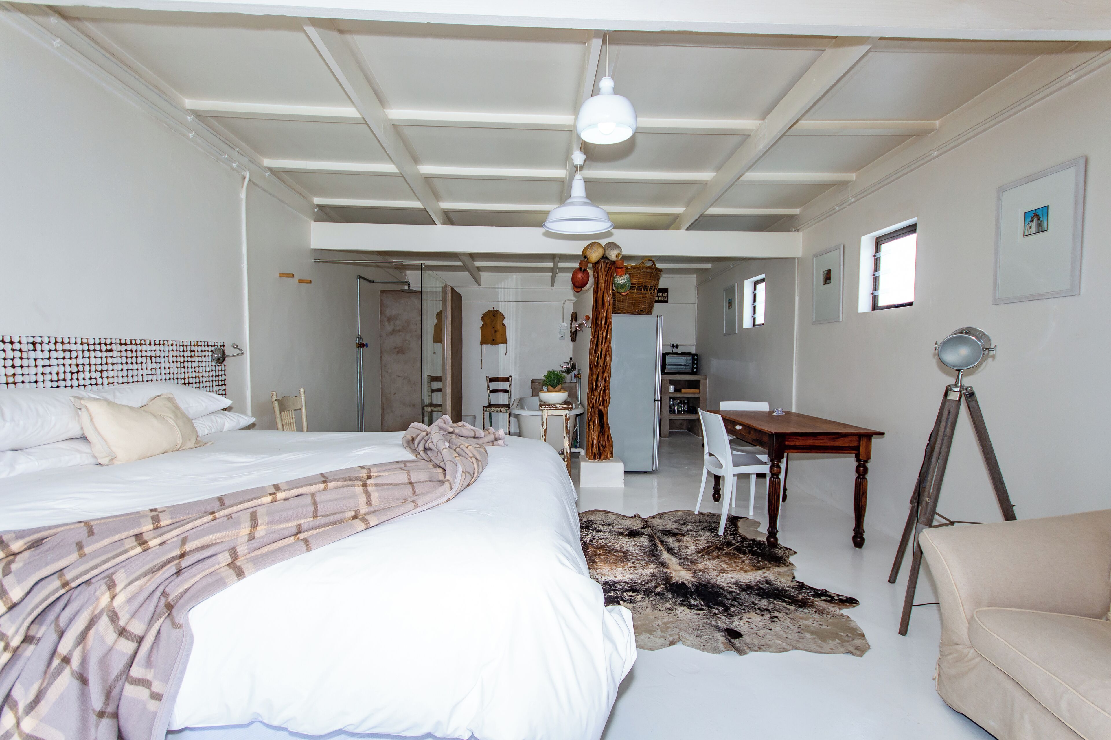A spacious bedroom with a large bed, a desk, and a chair.