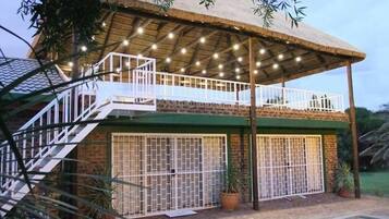 Set amidst lush surroundings, this charming building features a pool and a thatched upper level.