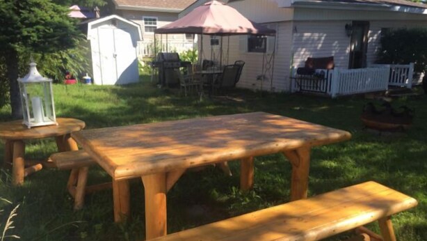 A wooden picnic table with benches in a backyard. - Diamond in the Bluff (Pointe-du-Chene)
