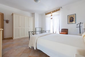 A bedroom with a bed, a wardrobe, a chair, and a radiator. - Casale Tre Petre (Galatone)
