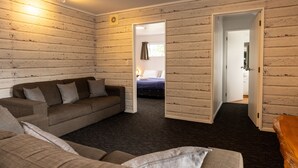 Una habitación con alfombra oscura, un sofá y una cama.
