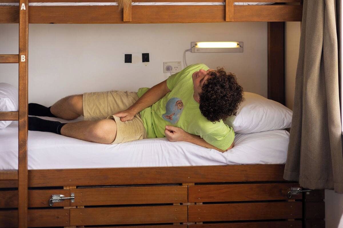 Ein Etagenbett mit zwei Schlafstellen, ein Nachttisch und eine Steckdose.