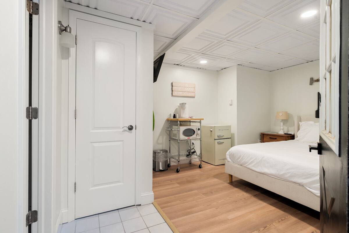 Une chambre d’hôtel équipée d’un lit, d’un bureau avec un ordinateur, d’un four à micro-ondes et d’un petit placard.
