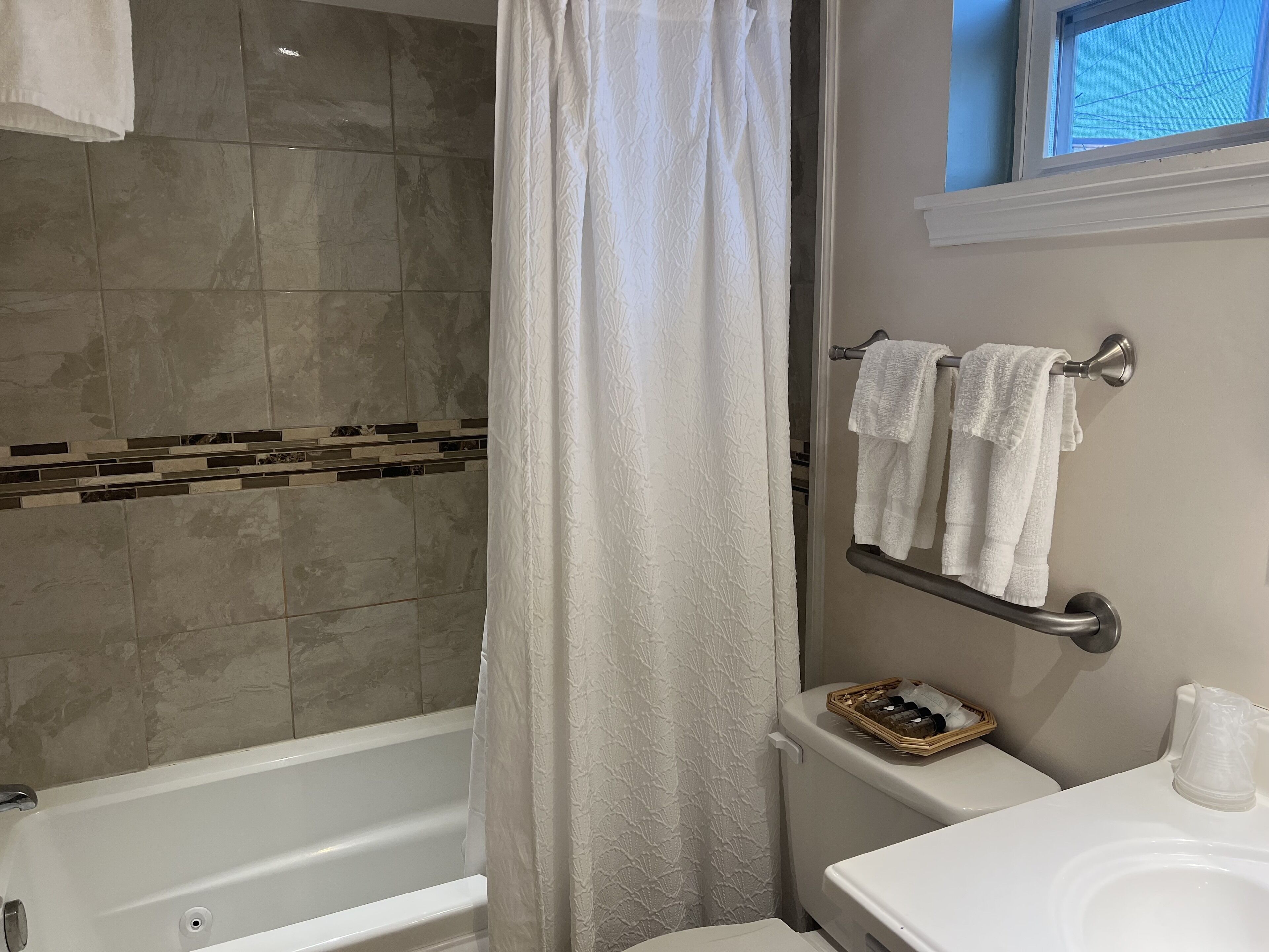 Un baño con bañera, inodoro y lavamanos.