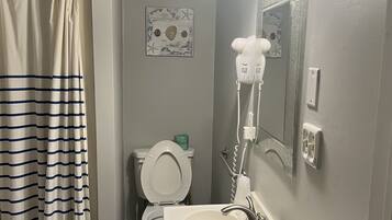 A bathroom with a toilet, sink, and shower curtain.