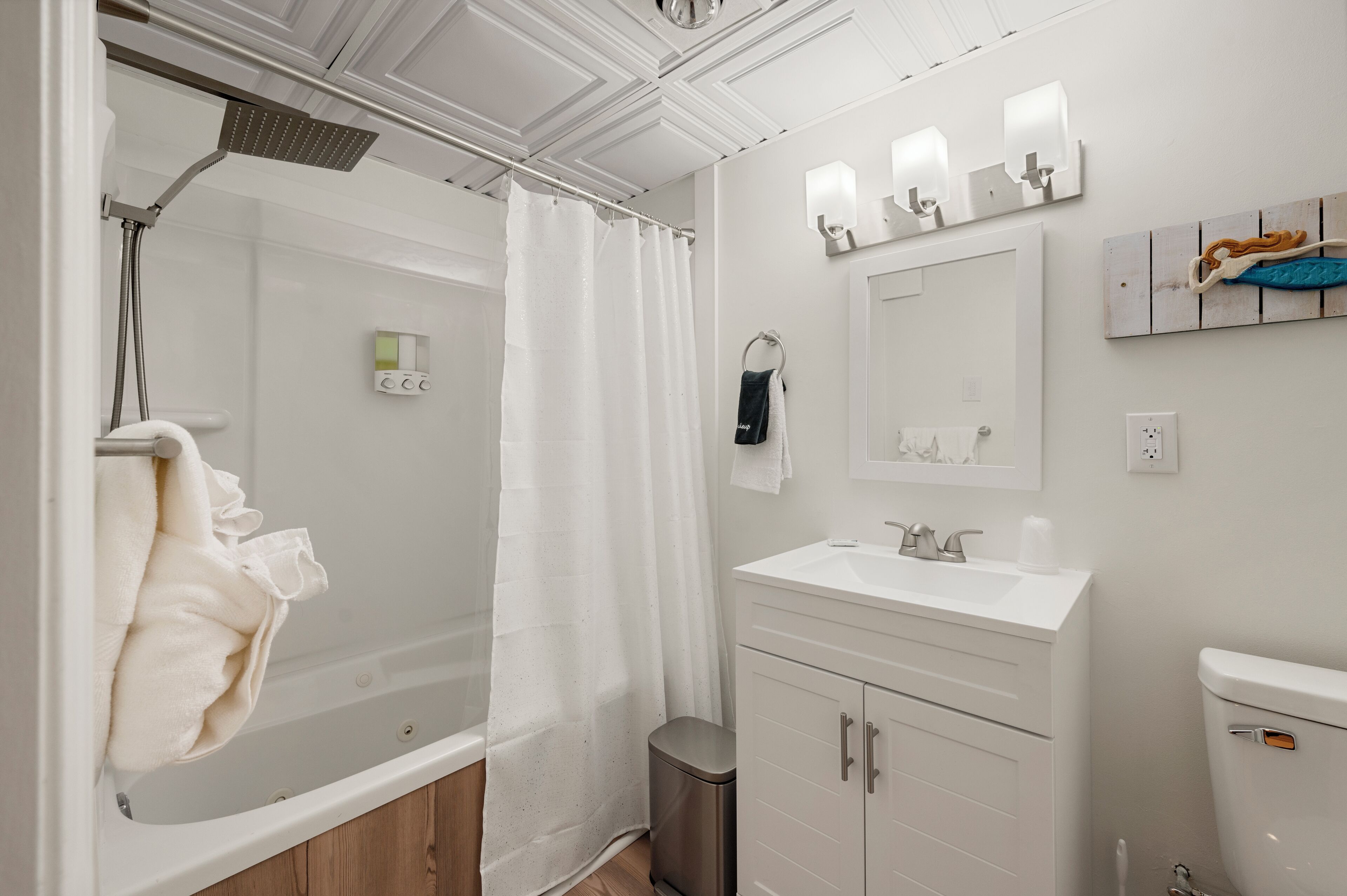 A modern bathroom with a shower, toilet, sink, and vanity.