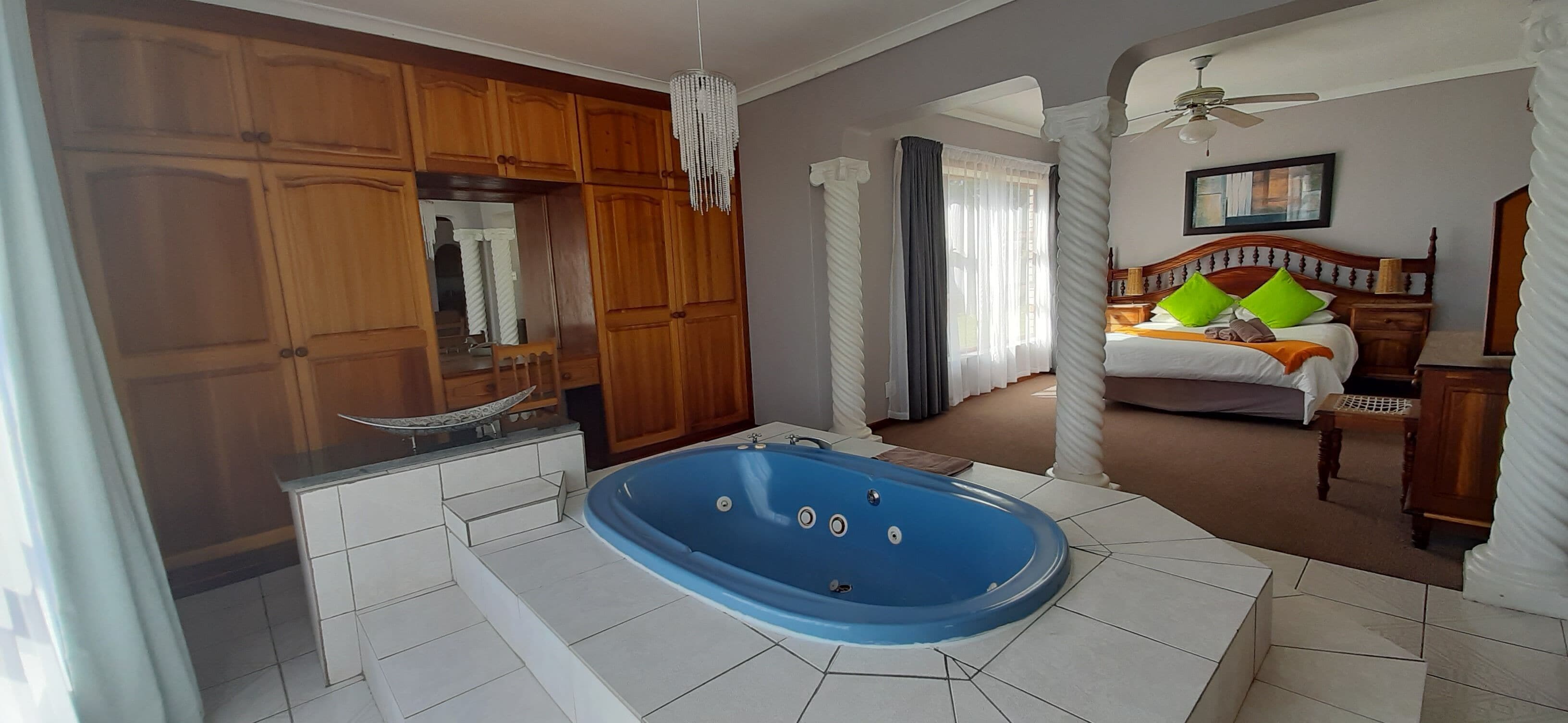 A bathroom with a bathtub, wooden cabinets, and a mirror.