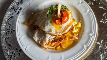 A plate with a sandwich, egg, beans, and a garnish.