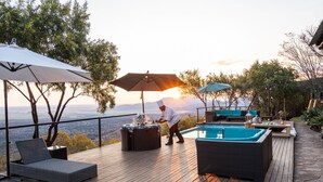A deck with a pool, lounge chairs, and umbrellas. - Humdani Game Lodge (Beestekraal)