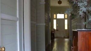 A hallway with a wooden cabinet and a door on the left. - Brooklyn Farm Bed and Breakfast (Myponga Beach)