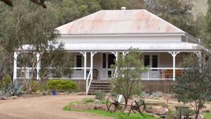 A white, two-story building with a gabled roof, surrounded by trees and a dirt path. - Brooklyn Farm Bed and Breakfast (Myponga Beach)