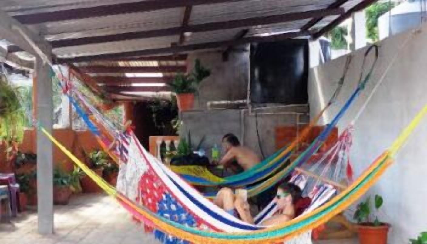 Una hamaca bajo una zona techada con un televisor montado en la pared.