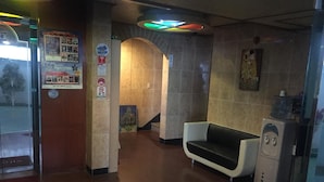 A lobby with a reception desk, a seating area, a water dispenser, and a staircase. - Prince Motel (Gwangju)